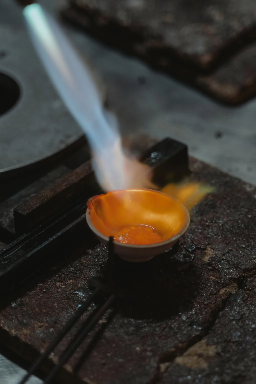 Fundição artesanal de joia em prata: cadinho com metal líquido no ateliê